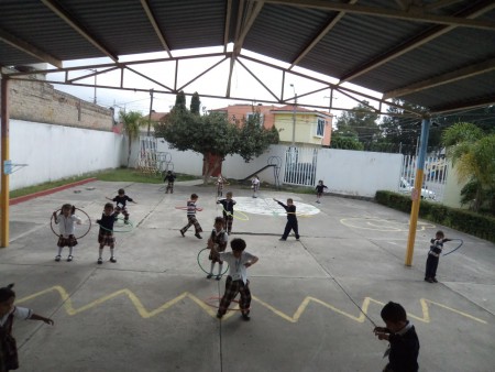 Educación física con aros, coordina, imprime fuerza y destreza.